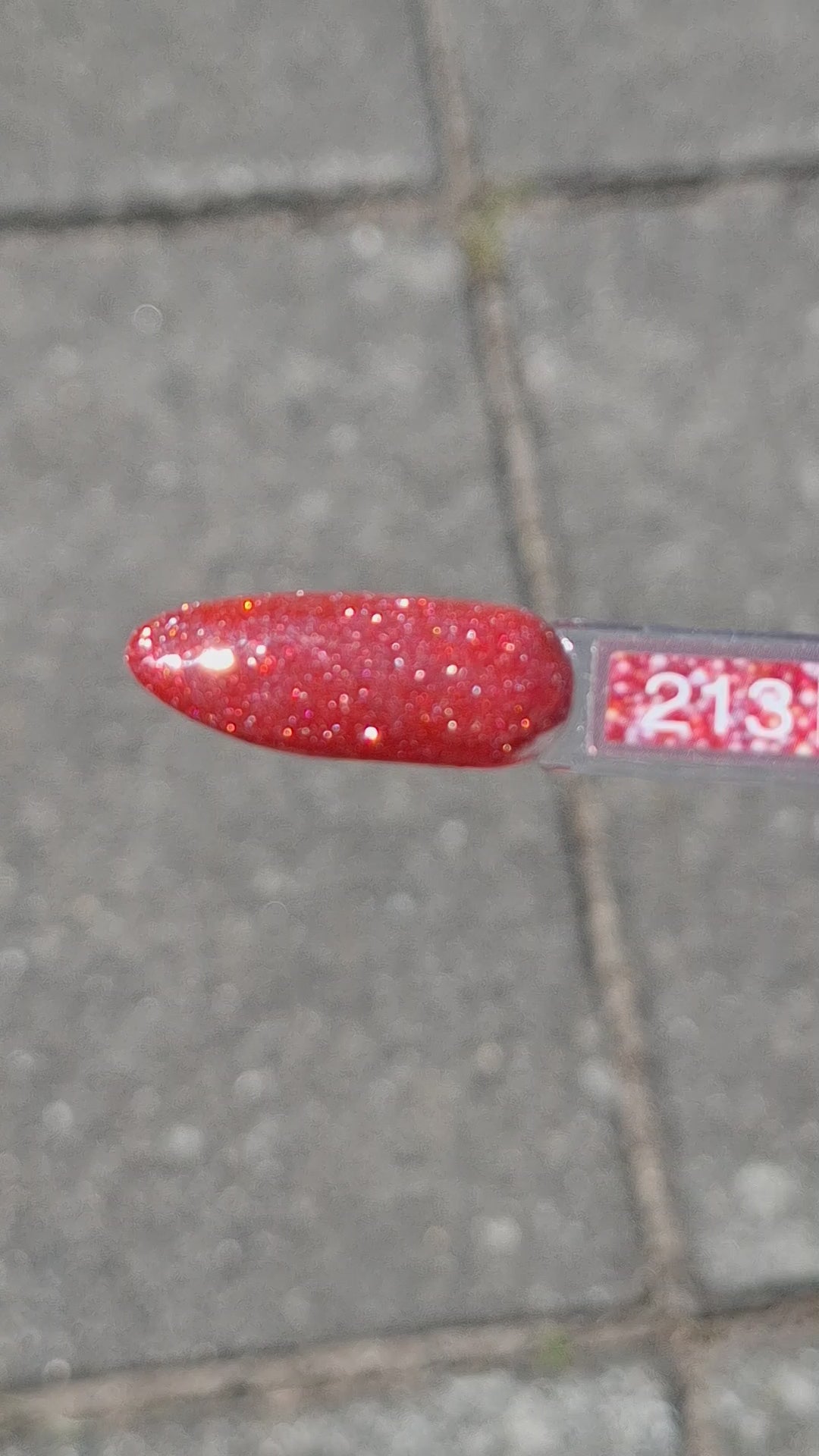 Quida Gelpolish 213 Milky Way Mood - warm koraalrood met holografische shimmer gelpolish aangebracht op nagels in het zonlicht, 15ml