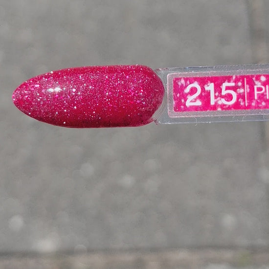 Quida Gelpolish 215 Planet Of Desire - warm frambozenrood met roze-rode glitter gelpolish aangebracht op nagels in het zonlicht, 15ml
