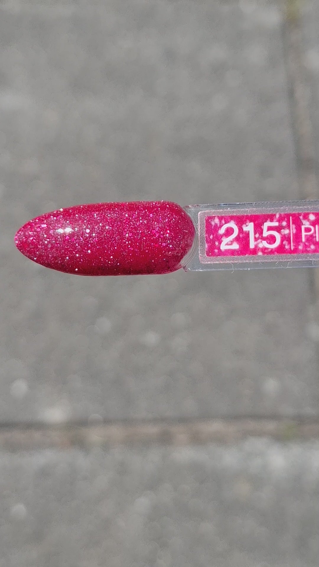 Quida Gelpolish 215 Planet Of Desire - warm frambozenrood met roze-rode glitter gelpolish aangebracht op nagels in het zonlicht, 15ml