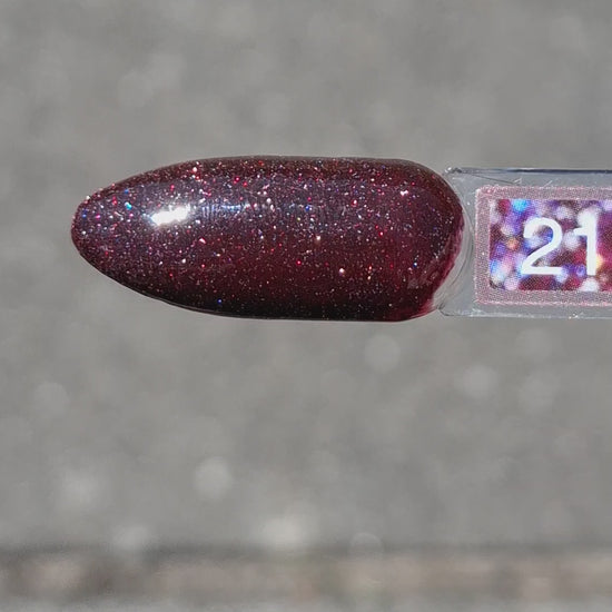Quida Gelpolish 216 Out Of This World - diep pruimrood met bordeaux microglitter gelpolish aangebracht op nagels in het zonlicht, 15ml