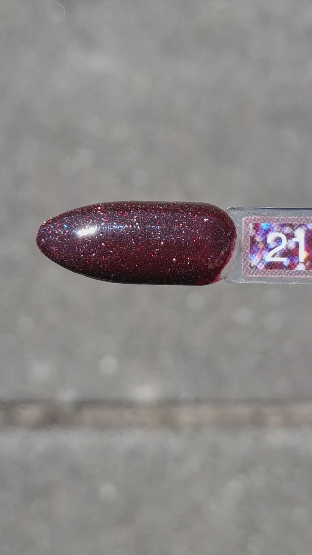 Quida Gelpolish 216 Out Of This World - diep pruimrood met bordeaux microglitter gelpolish aangebracht op nagels in het zonlicht, 15ml