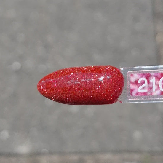 Quida Gelpolish 210 Starlit Secret - diep rood met vonkende glitter gelpolish aangebracht op nagels in het zonlicht, 15ml