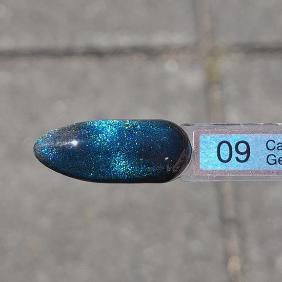 Quida Cat Eye Gelpolish 9 Emerald Sky - magnetisch blauw cat eye-effect gelpolish aangebracht op nagels met magneet in het zonlicht, 15ml