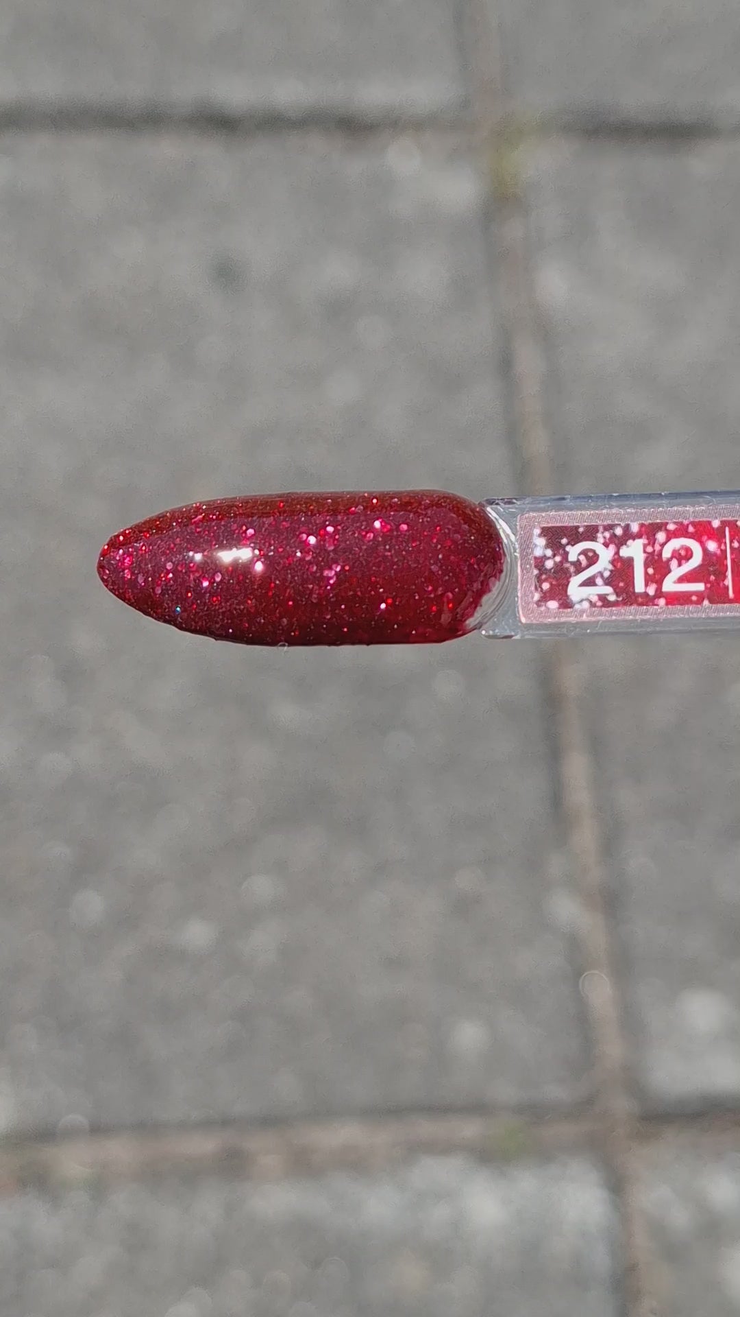 Quida Gelpolish 212 Moonlit Crush - diep bordeauxrood met warme rode glitter gelpolish aangebracht op nagels in het zonlicht, 15ml