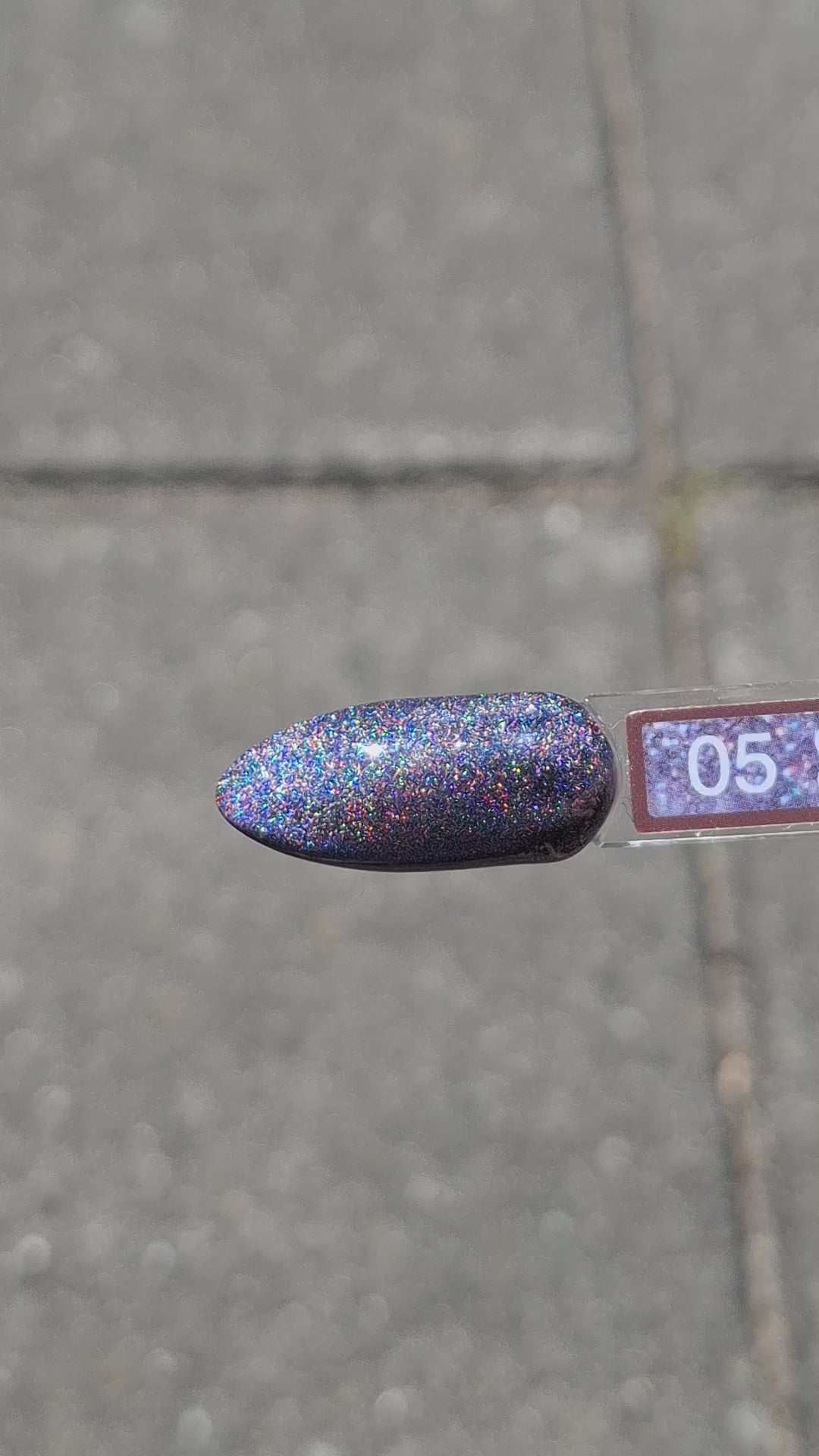 Quida Cat Eye Gelpolish 5 Spark - magnetisch lichtblauw roze cat eye-effect gelpolish aangebracht op nagels met magneet in het zonlicht, 15ml