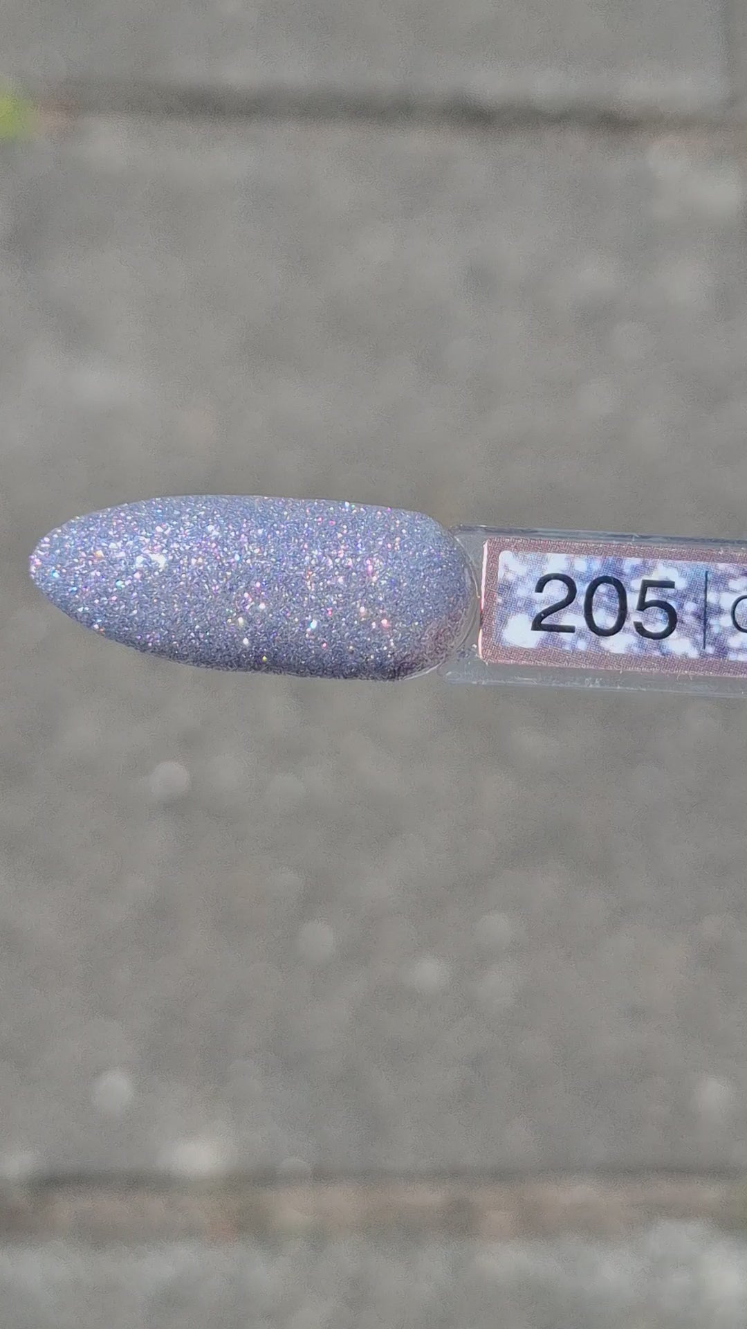 Quida Gelpolish 205 Gleam Theory - zilver met blauwe glitter gelpolish aangebracht op nagels in het zonlicht, 15ml