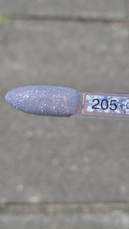Quida Gelpolish 205 Gleam Theory - zilver met blauwe glitter gelpolish aangebracht op nagels in het zonlicht, 15ml