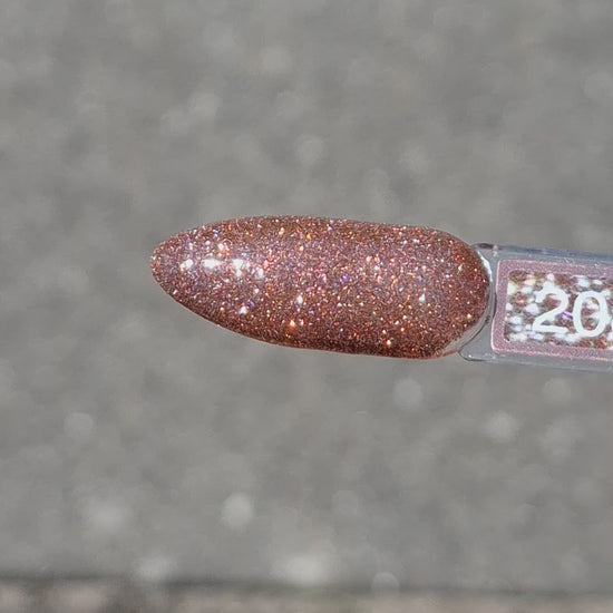 Quida Gelpolish 208 Aura Glow - warm bruin-brons met fijne glitter gelpolish aangebracht op nagels in het zonlicht, 15ml