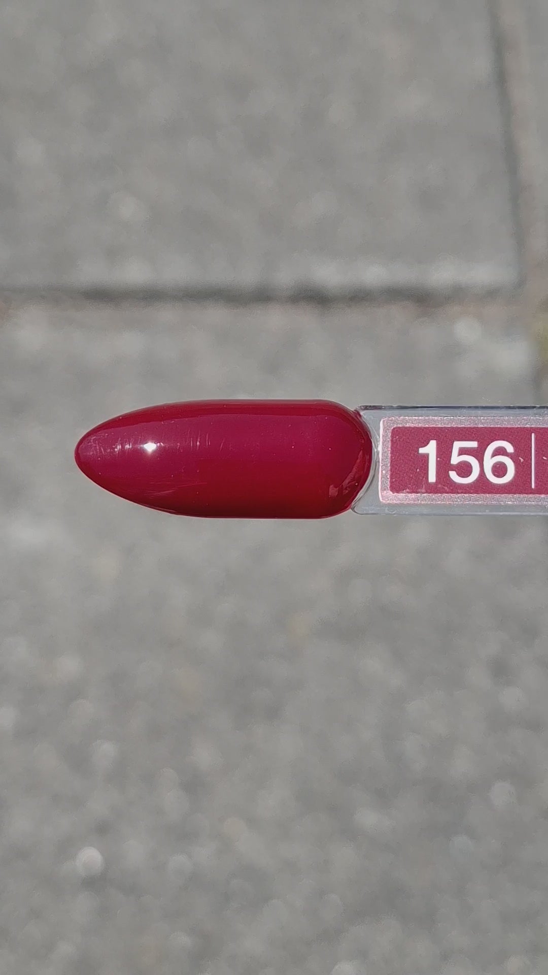 Quida Gelpolish 156 Scarlet Secret - diep donkerrode gelpolish aangebracht op nagels in de zon, 15ml