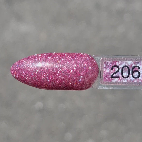 Quida Gelpolish 206 Crystal Crush - warm roze met mauve-paarse glitter gelpolish aangebracht op nagels in het zonlicht, 15ml
